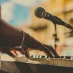 Musician playing piano and singing with a microphone outdoors in San Juan.